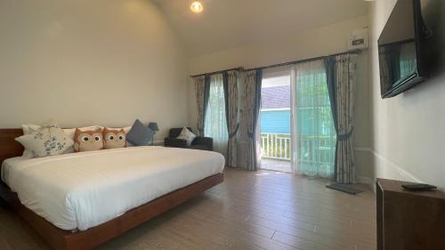 Ban Na SokVermont Khao Yai Resort的一间卧室设有一张床和一个大窗户