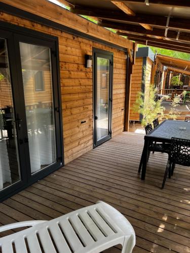 格里莫格里莫港最佳假日露营地的木甲板上配有桌子和长凳
