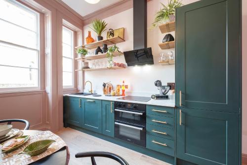 布里斯托The Half Angel - 1 Bedroom Apartment in Central Bristol by Mint Stays的厨房配有蓝色橱柜和炉灶。