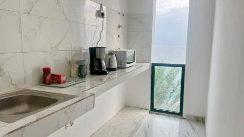 ŢīwīWadi Shab Beach Resort的厨房配有水槽和微波炉