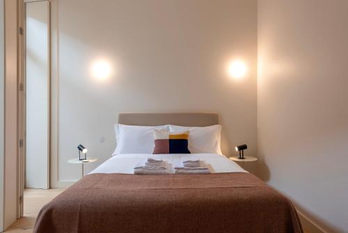 波尔图Mouzinho 32的一间卧室配有一张大床和两条毛巾