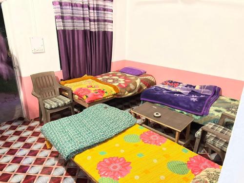 布什格尔Baba hostel的带三张床和桌椅的房间
