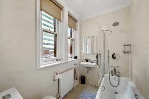 伦敦Delightful Flat in London - Sleeps 6的白色的浴室设有水槽和浴缸。