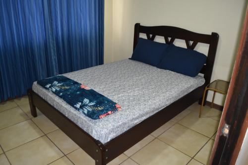 图里亚尔瓦SERENITY HOME H Y M的床上铺有蓝色枕头和蓝色毯子