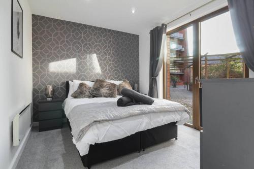 谢菲尔德Stylish modern home in Sheffield的一间卧室设有一张床和一个大窗户