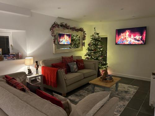 斯基普顿Tosside Fold Farm Cottage的带沙发和圣诞树的客厅