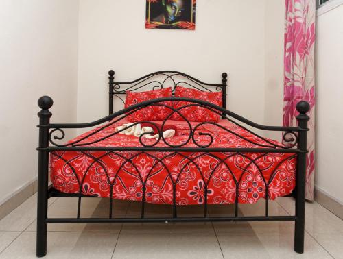 利伯维尔Résidence Céline的一张黑色的床,配有红色枕头