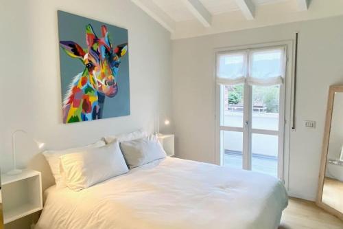 布雷西亚Le Terrazze 18的一间卧室配有一张带长颈鹿绘画的床
