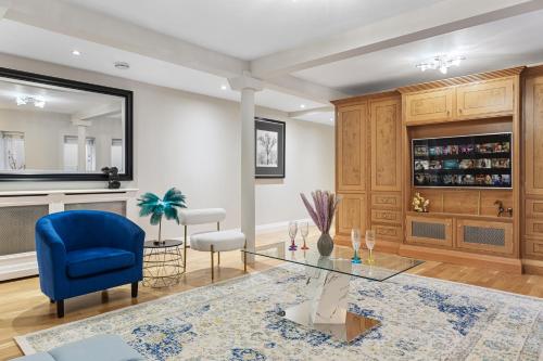 伦敦ULTRA MASSIVE House by HYDE PARK的客厅配有蓝色椅子和玻璃桌