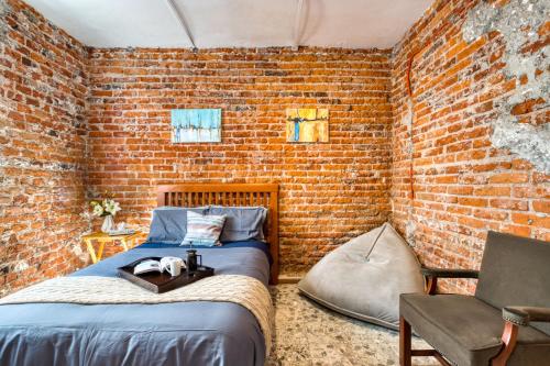 墨西哥城Casa Lumo in Roma Norte by Tasman的一间卧室设有一张床和砖墙