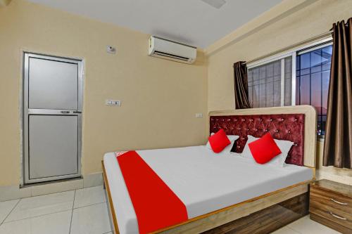 兰奇OYO Flagship 81208 Jagarnath Palace的一间卧室配有一张带红色枕头的床和一扇窗户
