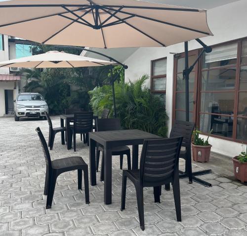 佩德纳莱斯HOTEL PLAYAS PERDERNALES ECUADOR的庭院内桌椅和遮阳伞