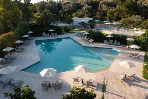 达西亚Nafsika Hotel - Adults Only的享有带椅子和遮阳伞的游泳池的上方景致