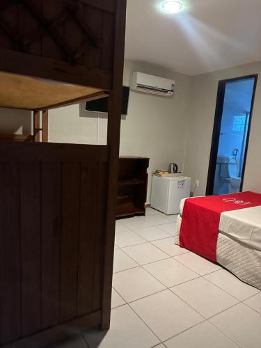 嘎林海斯港Pousada Flor de Maraca的一间卧室配有一张带红色毯子的床