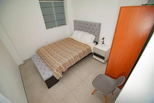 塔克纳Moderno y acogedor departamento的一间小卧室,配有一张床和一把椅子
