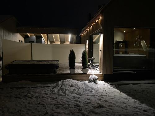 诺基亚Guesthouse with sauna & hot tub的夜晚在地上积雪的房子