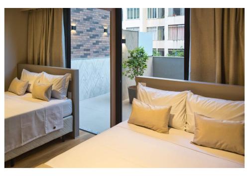贝洛奥里藏特Life Residence的一间卧室配有两张带枕头的床和一个阳台