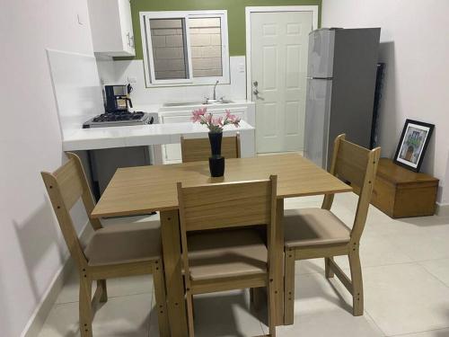 科潘省圣罗莎Céntrico Apartamento的带木桌和椅子的厨房以及带冰箱的厨房。