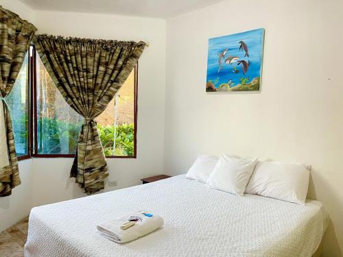 巴克里索莫雷诺港Hostal Vista al Mar的卧室配有白色的床和窗户。