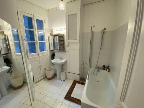 巴黎Le Cœur de l’Île Saint-Louis, you will love it!的白色的浴室设有浴缸和水槽。