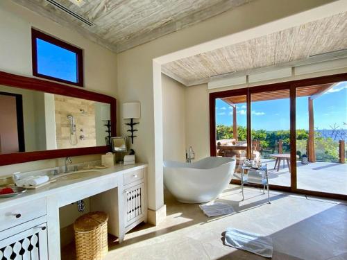 托拉Mukul Resort的一间带大浴缸和大窗户的浴室