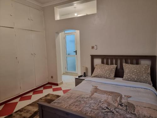坎帕拉Well Furnished and Airconditioned Rooms in Nakasero, Kampala By BoB的一间卧室设有两张床,铺有一个 ⁇ 板地板