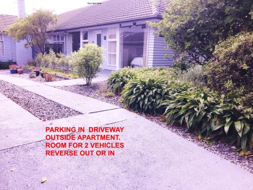 Pukerua BayPeaceful Pukerua Bay的带有标志的房子,上面写着车道上停车的标志,位于公寓房外