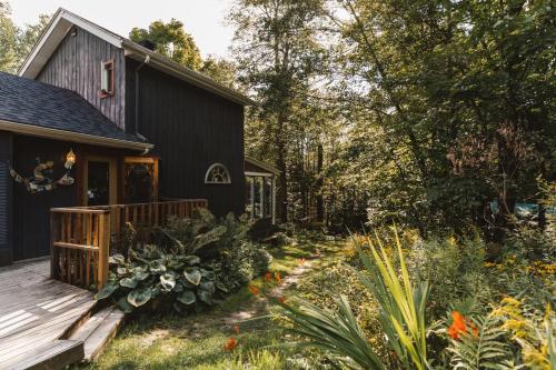 布罗姆湖Auberge Yoga Salamandre的黑色房子,设有甲板和花园