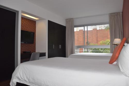 布宜诺斯艾利斯Hotel BA Abasto的卧室配有白色的床和窗户。