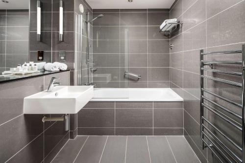 卡迪夫加的夫丽笙酒店的浴室配有盥洗盆和浴缸。