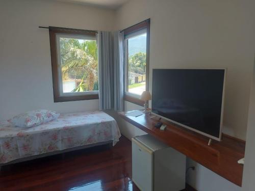 帕拉蒂Casarão Caborê的一间卧室配有一张床和一台平面电视