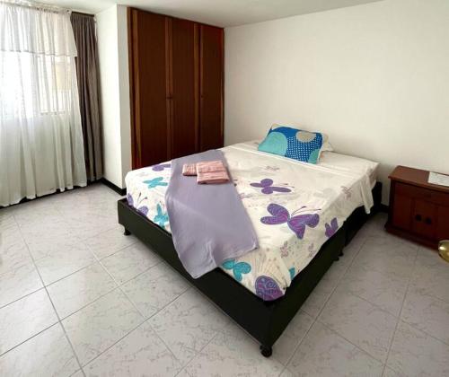 佩雷拉Cómodo apartamento en la Villa Olímpica de Pereira的一间卧室配有一张床和被子