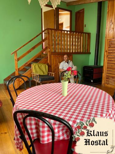 普孔Hostal Klaus的坐在桌子上的人,用红白的桌布