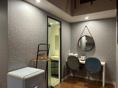 釜山艾丽西亚精品酒店的浴室设有两把椅子和镜子