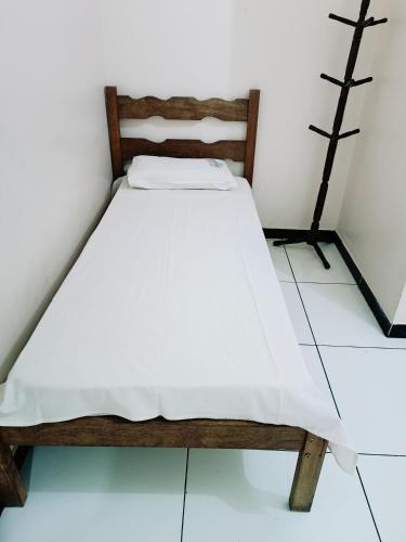 邦热苏斯-达拉帕Hotel e Lanchonete Bom Gosto的白色墙壁的客房内的一张小床