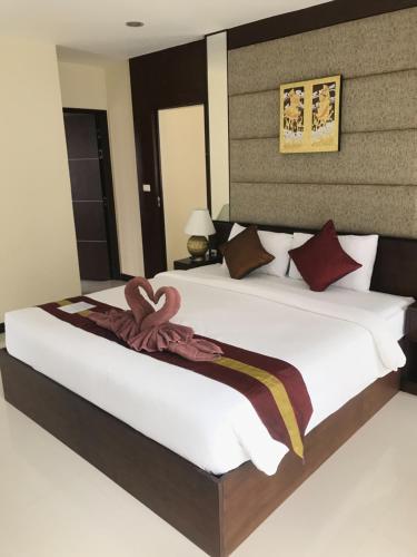 奥南海滩The Lai Thai Luxury Condominiums- Sha Extra Plus的卧室配有一张白色大床和棕色床头板