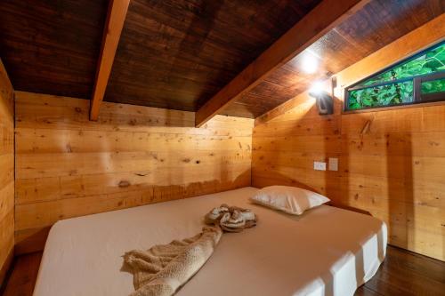 图里亚尔瓦Cabaña La Montaña: Vistas increíbles y Mirador的木制客房内的一间卧室,配有一张床