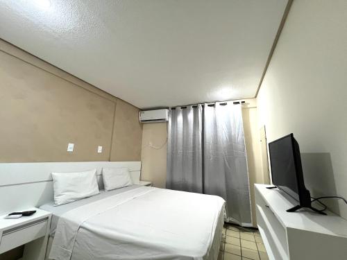 圣路易斯Flat number one temporadalitoranea的卧室配有白色的床和电视。