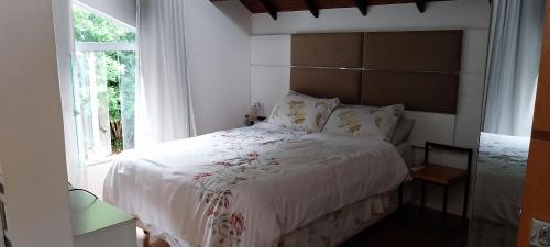 伊泰帕瓦Casa de Campo - Vista da montanha的卧室配有白色的床和窗户