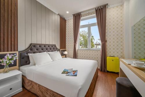 大叻Be U Hotel City View的卧室设有一张白色大床和一扇窗户。