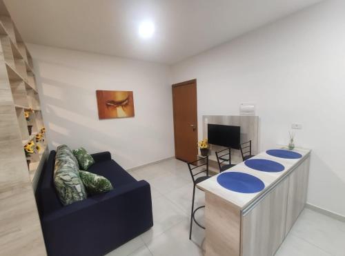 奥林匹亚Flat Brilho do Sol的客厅配有蓝色的沙发和桌子
