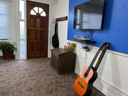 蓬塔阿雷纳斯Casa的蓝墙房间内的吉他
