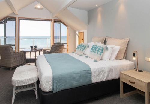 新普利茅斯Beachfront Bliss On Wanaka Terrace Support Local的一间卧室设有一张床,享有海景