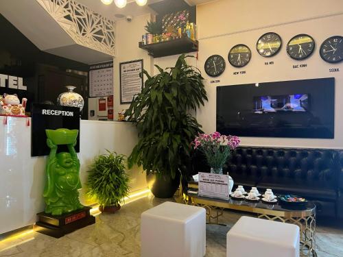 Bắc GiangSky Hotel的墙上挂着时钟的商店和沙发