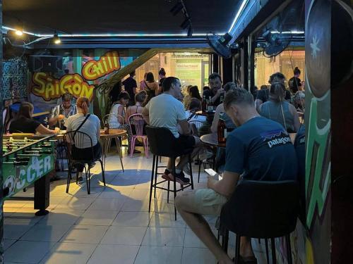 胡志明市Saigon Chill Hostel的一群坐在餐厅桌子上的人