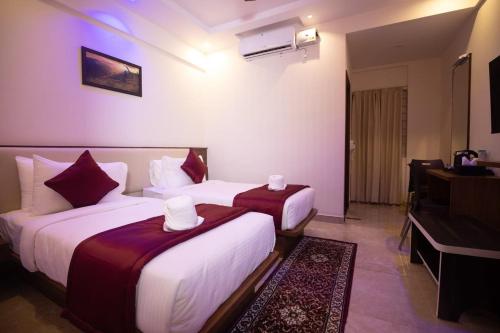 耶拉汉卡Hotel Grand Villa的酒店客房设有两张床和电视。