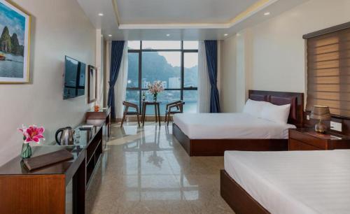 吉婆岛Aroma Cat Ba Sea View Hotel的酒店客房设有两张床和一张桌子。