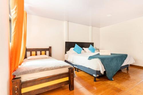 迦太基Refugio Sereno en Cartago B&B的一间卧室配有两张带蓝色枕头的床