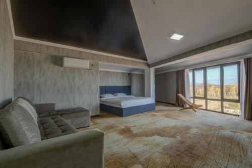 博斯特里Vzmorie Resort Hotel的一间卧室配有一张床和一个沙发