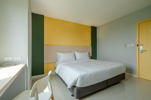 帕夭พิลโล่ อินน์ พะเยา Pillow Inn Phayao的一间卧室设有一张床,墙壁黄色和绿色